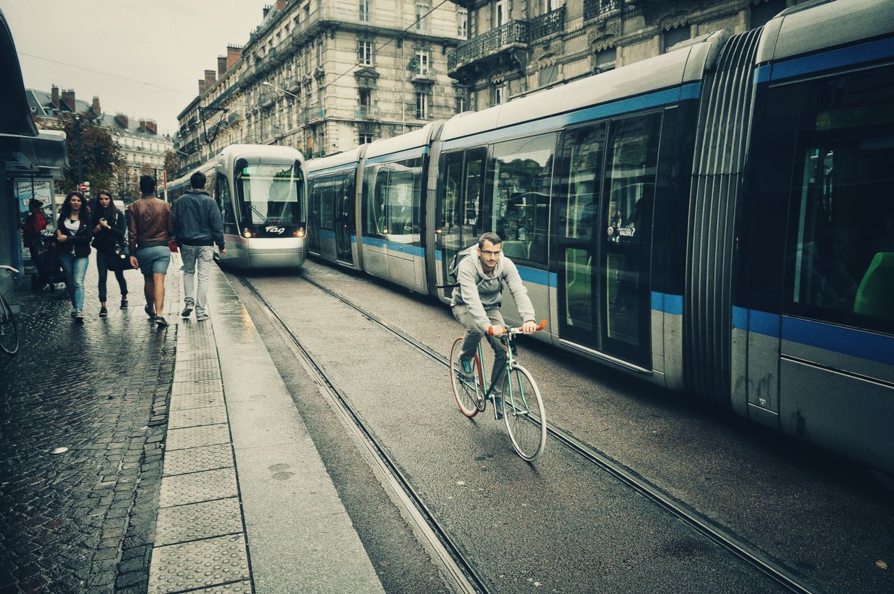 Person beim Radfahren in der Stadt neben einer Straßenbahn