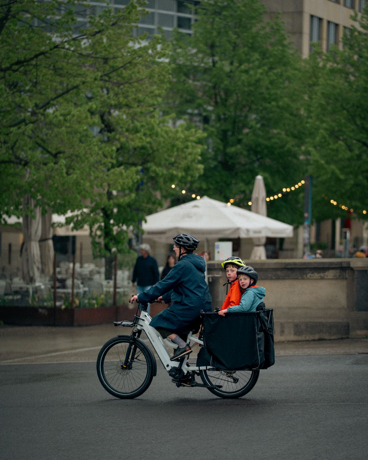 Eltern mit zwei Kindern auf einem Lastenfahrrad